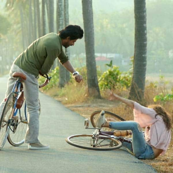 Shah Rukh Khan offers a helping hand to Alia Bhatt as she falls off the cycle.